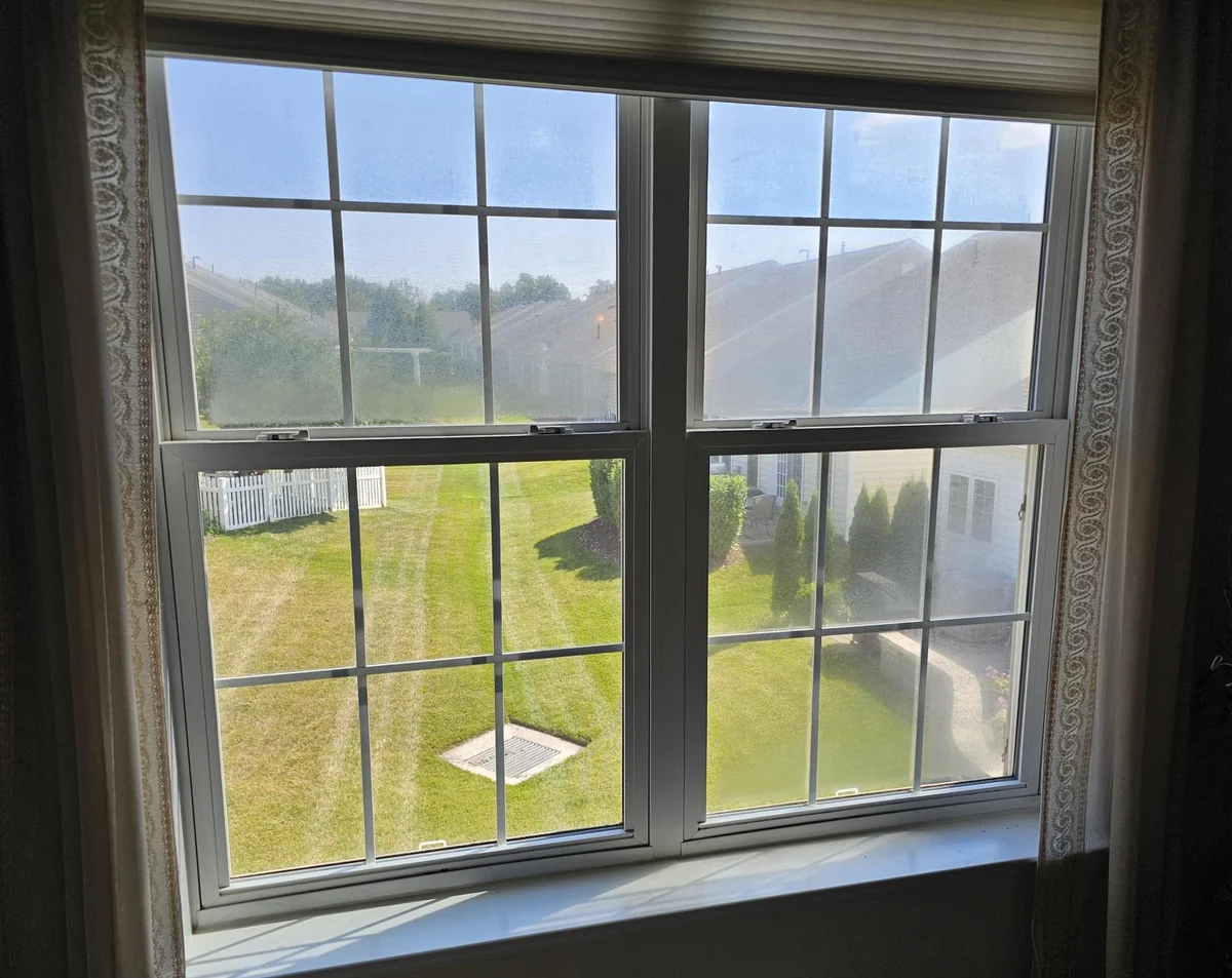 Paired double-hung windows with cloudy glass in the upper panes.