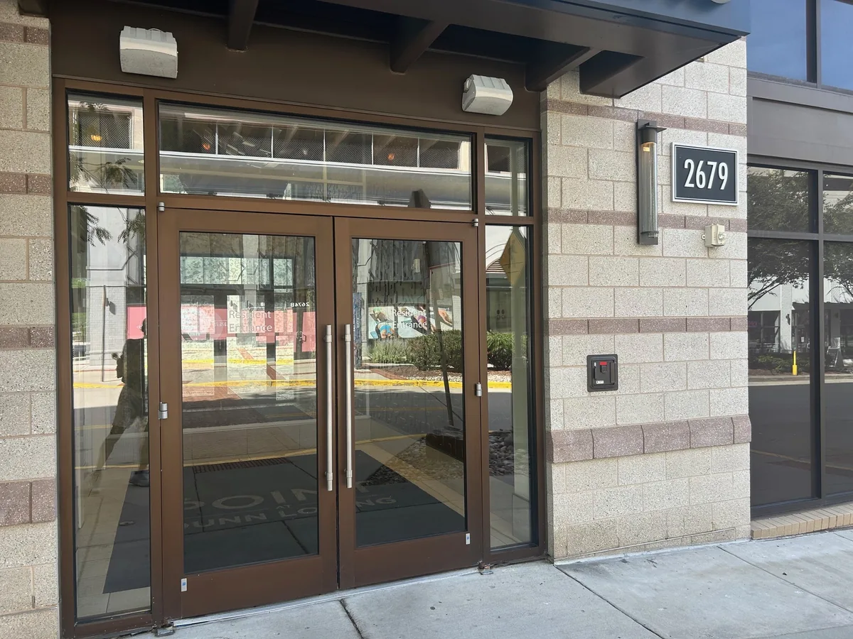 Bronze-colored double glass entrance doors with transom and side glazing.