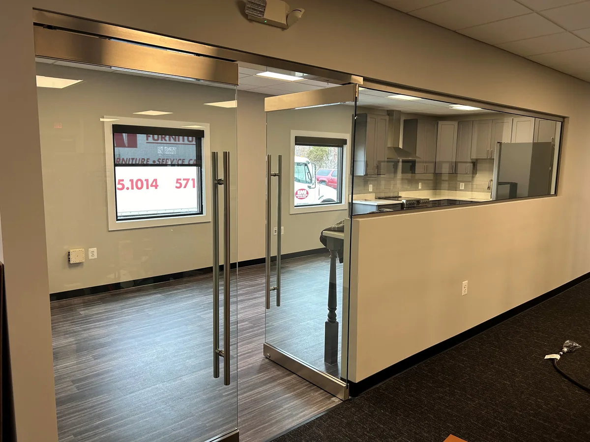 Glass office entrance with long pull handles and a glazed partition