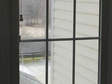 Cloudy divided-light window sash before glass replacement.