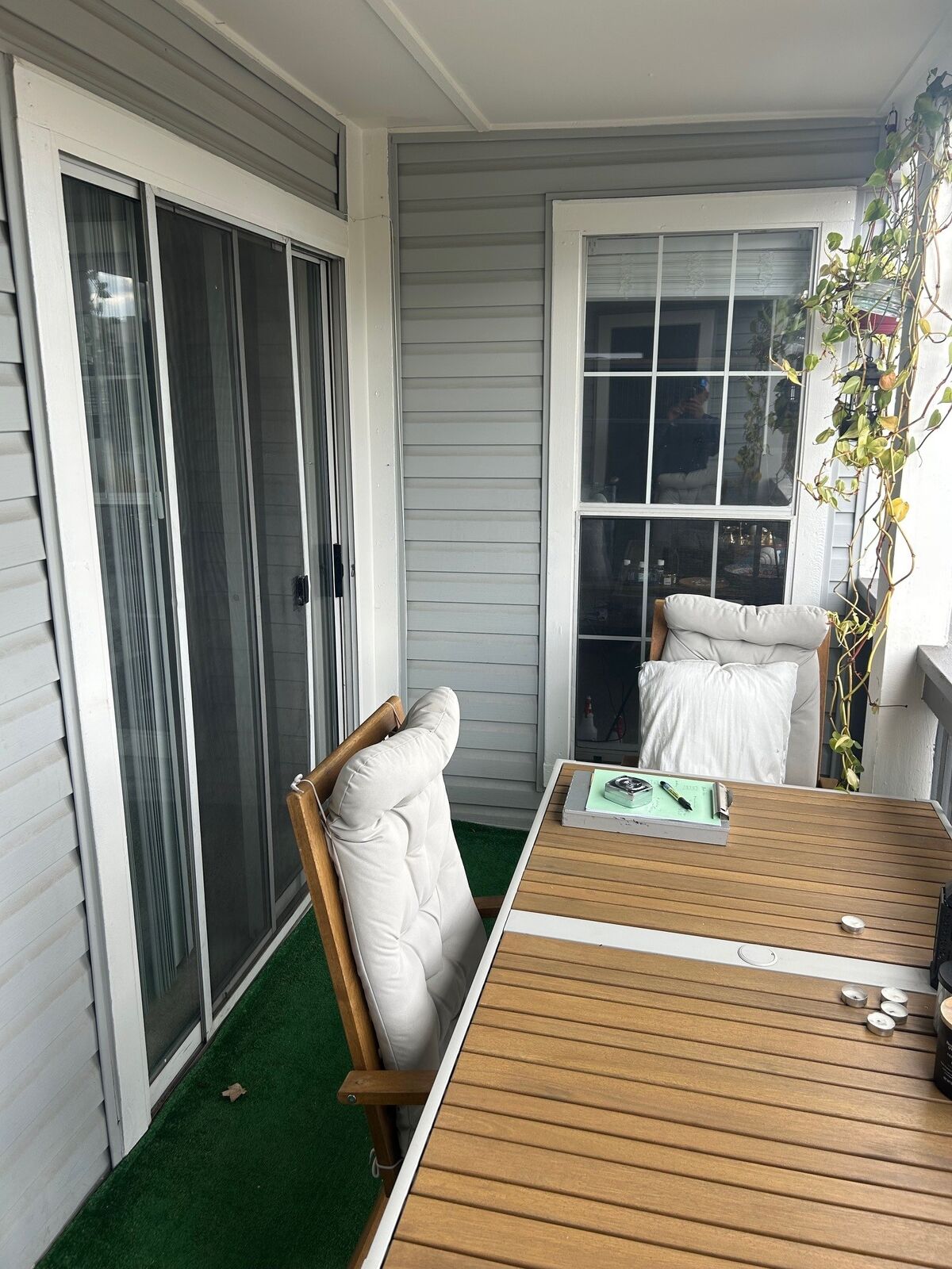 A covered balcony with a grid window and a sliding glass door