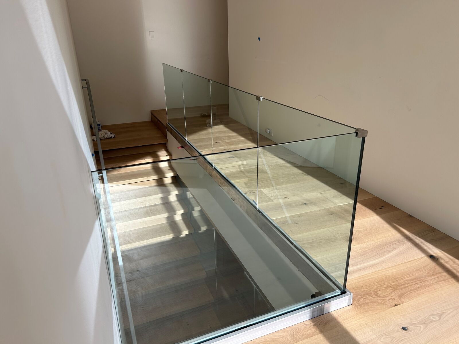 A glass railing around an interior stair opening