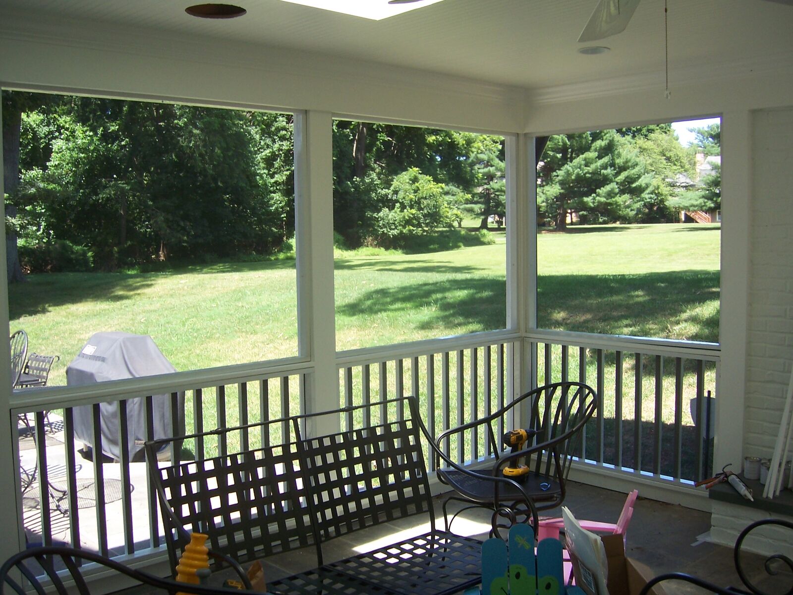 The inside of a screened porch overlooking a lawn