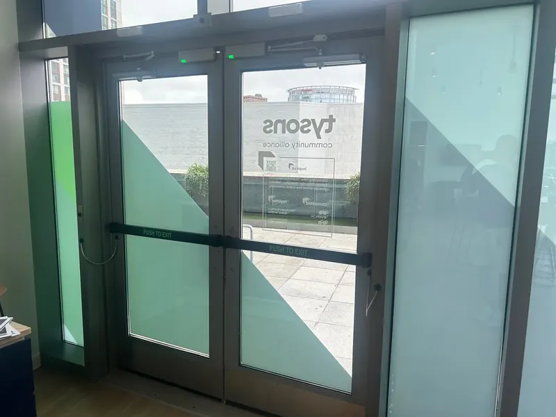 Double glass entry doors with geometric privacy graphics.