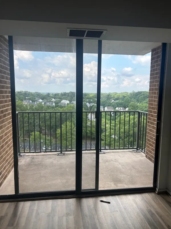 A dark-framed sliding patio door opens onto a balcony.