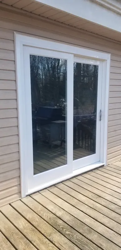 White sliding patio door opening onto a wood deck.