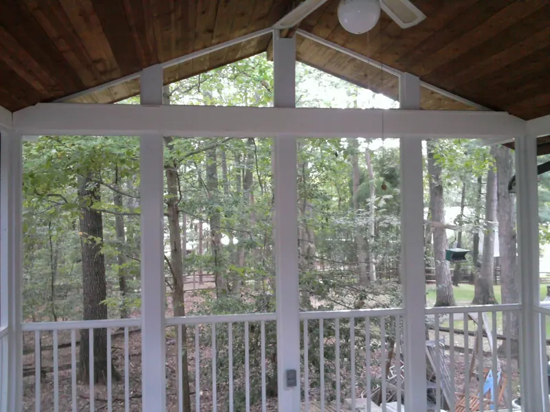 Screened porch gable overlooking a wooded yard.
