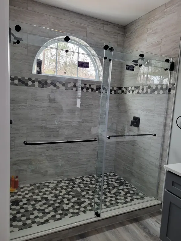 Black hardware shower below arched window.