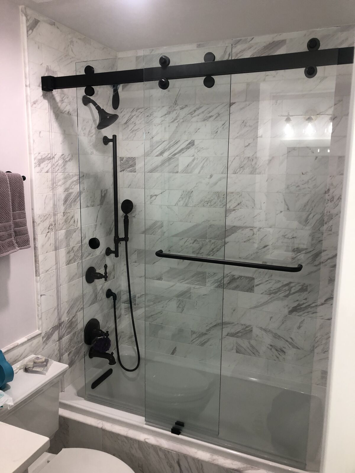 Black roller sliding glass doors on a bathtub