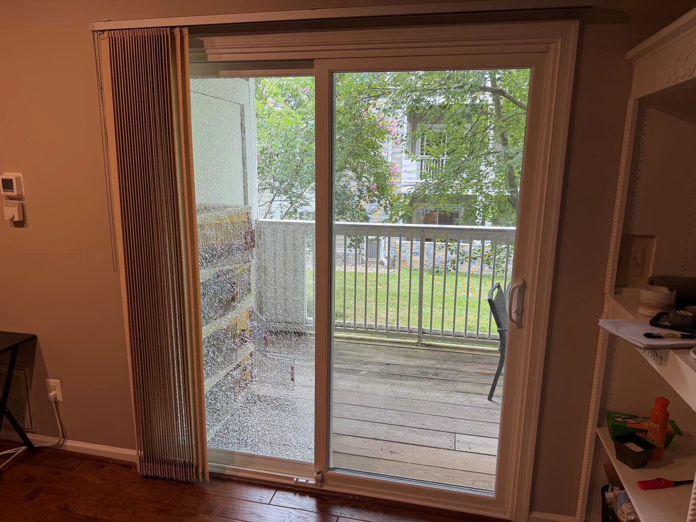 A sliding patio door with a shattered fixed glass panel beside its operable panel