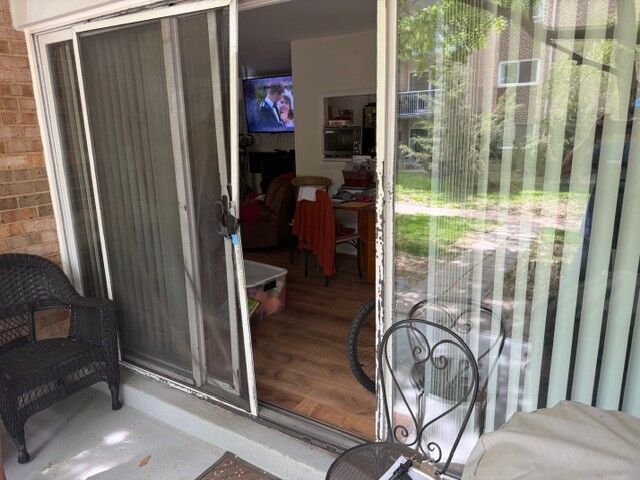 A sliding screen door pulled open beside a sliding glass patio door