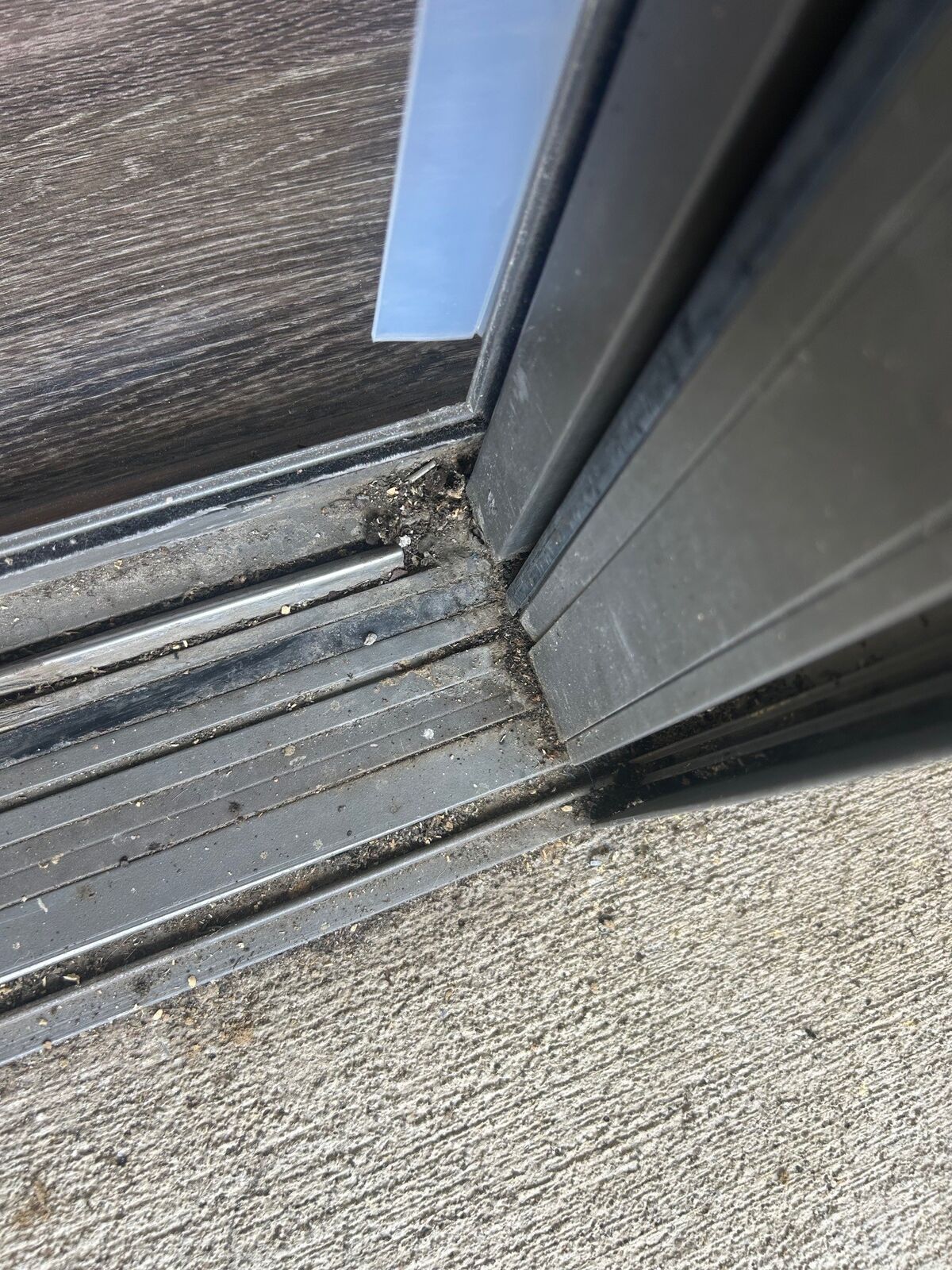 Close-up of the corner of a dirty sliding balcony-door track
