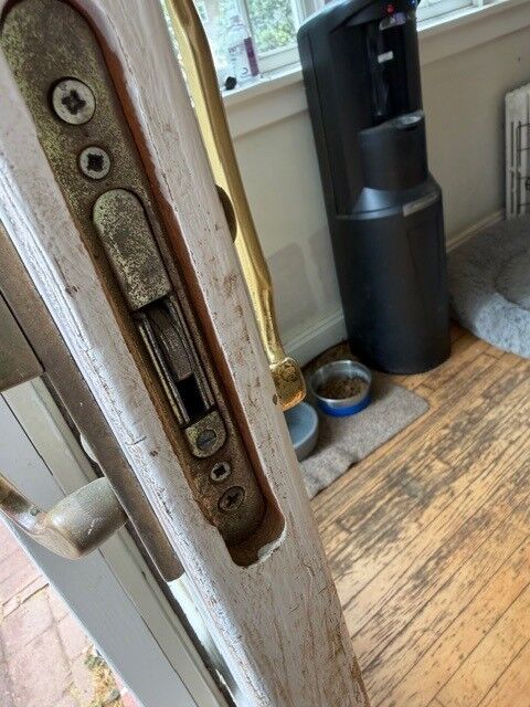 The edge of a patio door showing the lock mechanism and a brass handle