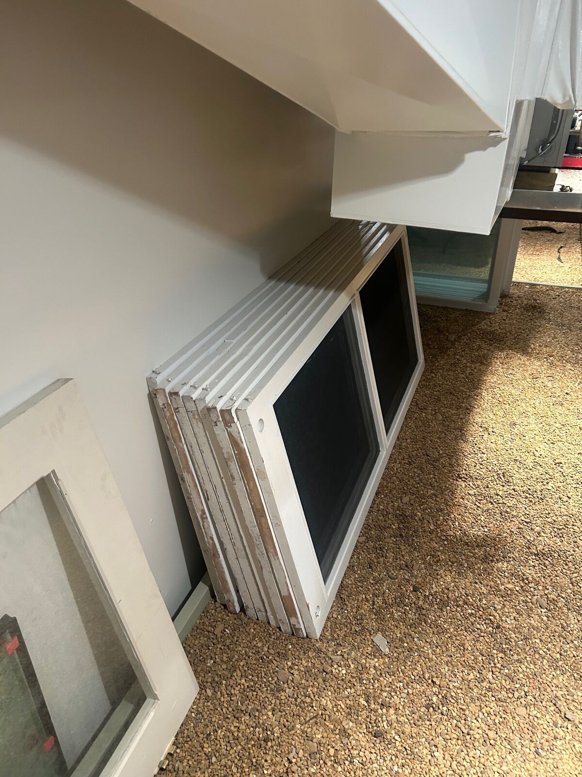 Stacked white window screen frames in a work area